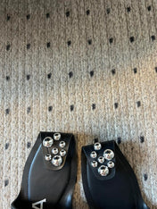ALAIA FOLDED FLAT MULES WITH SPHERES ON BLACK CALFSKIN