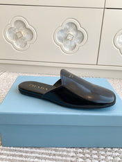 MULES IN BLACK GLOSSY SHEEPSKIN GOLD LETTERING LOGO