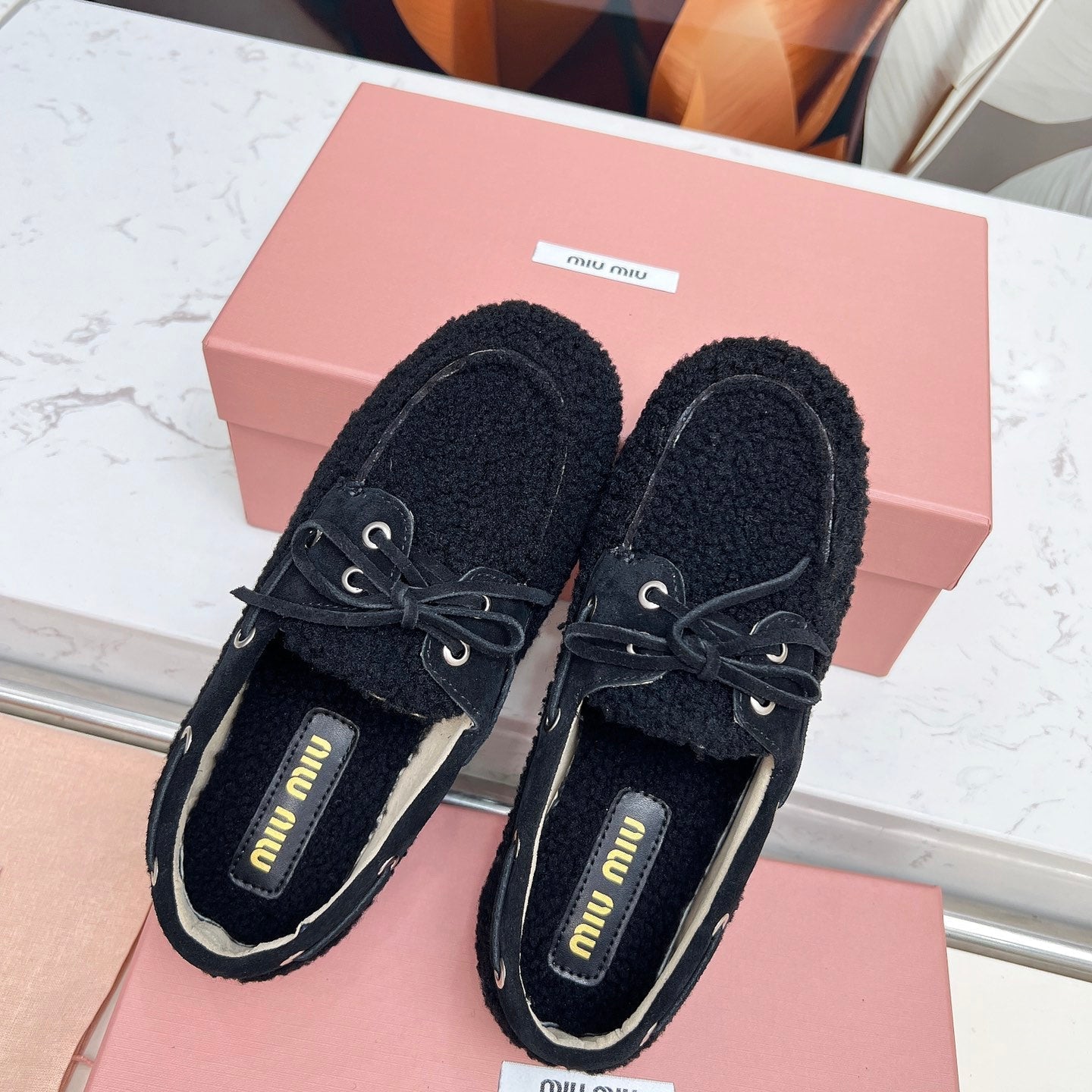 MIUMIU 26S BOAT LOAFERS IN BLACK SHEARLING