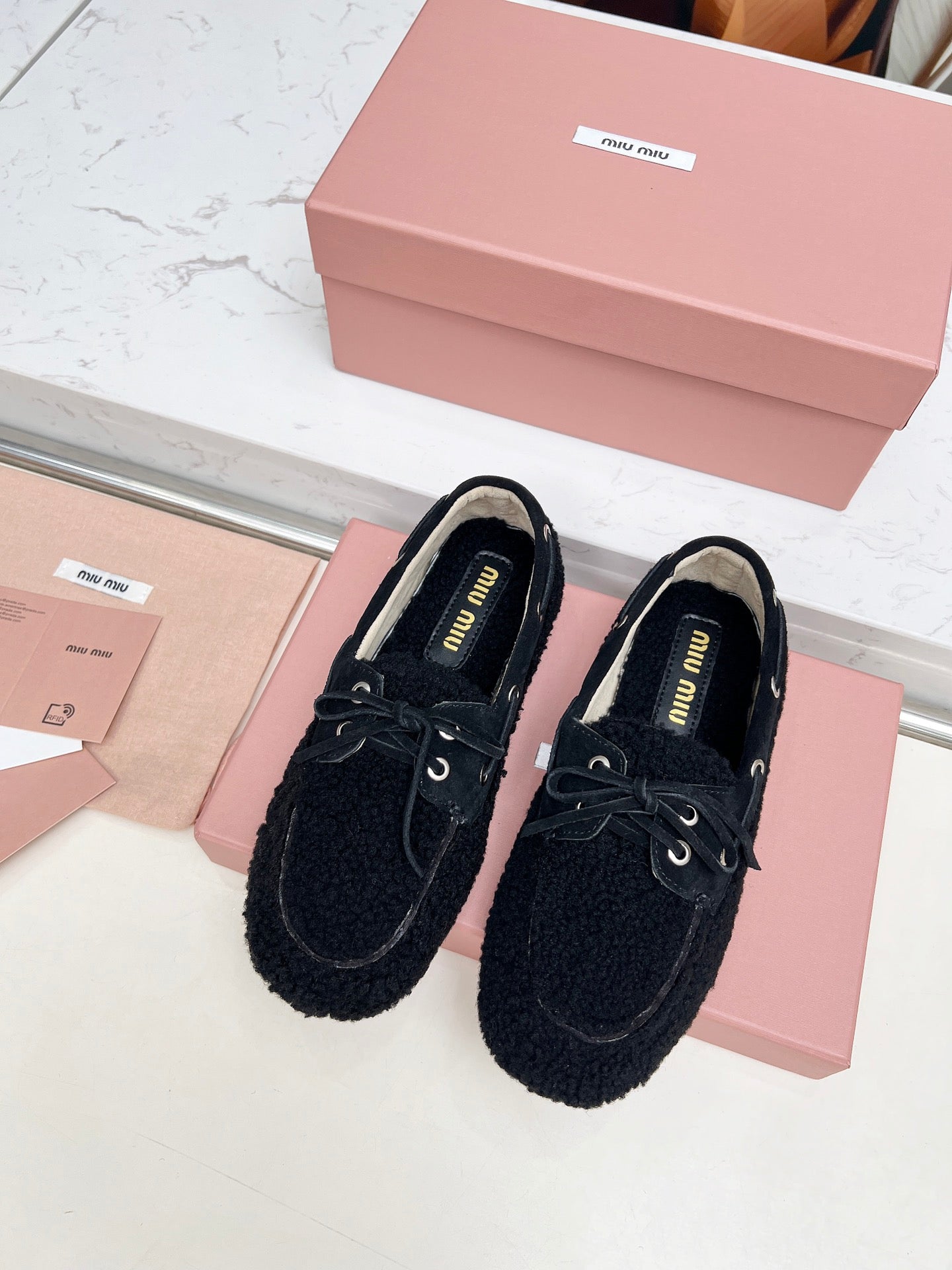 MIUMIU 26S BOAT LOAFERS IN BLACK SHEARLING