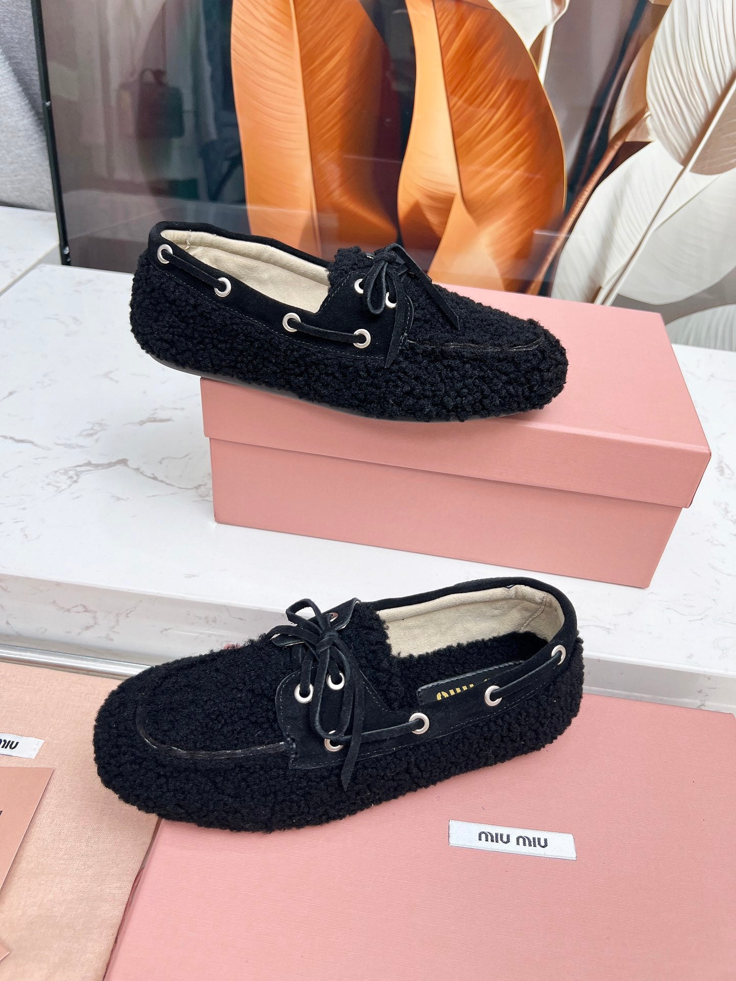 MIUMIU 26S BOAT LOAFERS IN BLACK SHEARLING