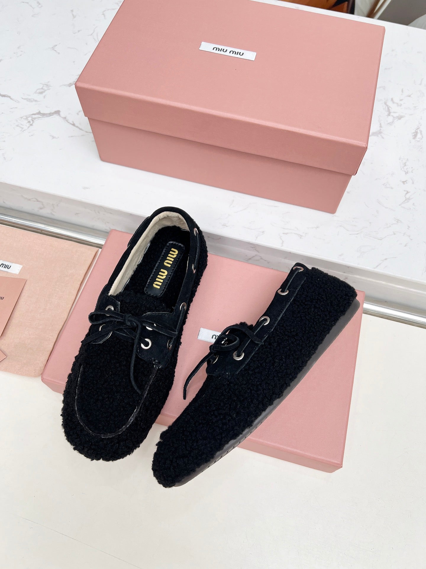 MIUMIU 26S BOAT LOAFERS IN BLACK SHEARLING