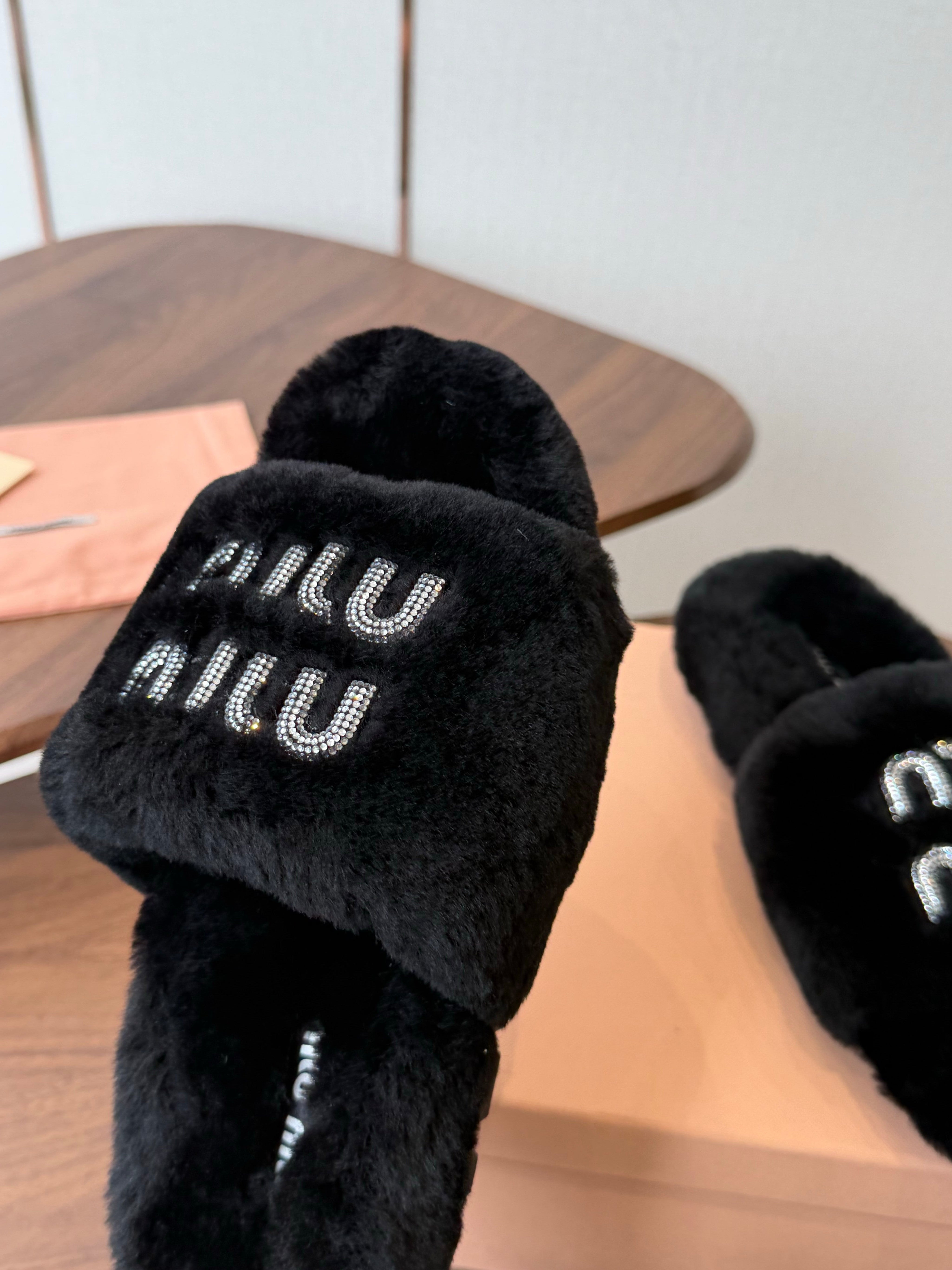 MIUMIU 26S CRYSTAL LOGO SLIDES IN BLACK SHEARLING