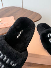 MIUMIU 26S CRYSTAL LOGO SLIDES IN BLACK SHEARLING