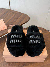 MIUMIU 26S CRYSTAL LOGO SLIDES IN BLACK SHEARLING