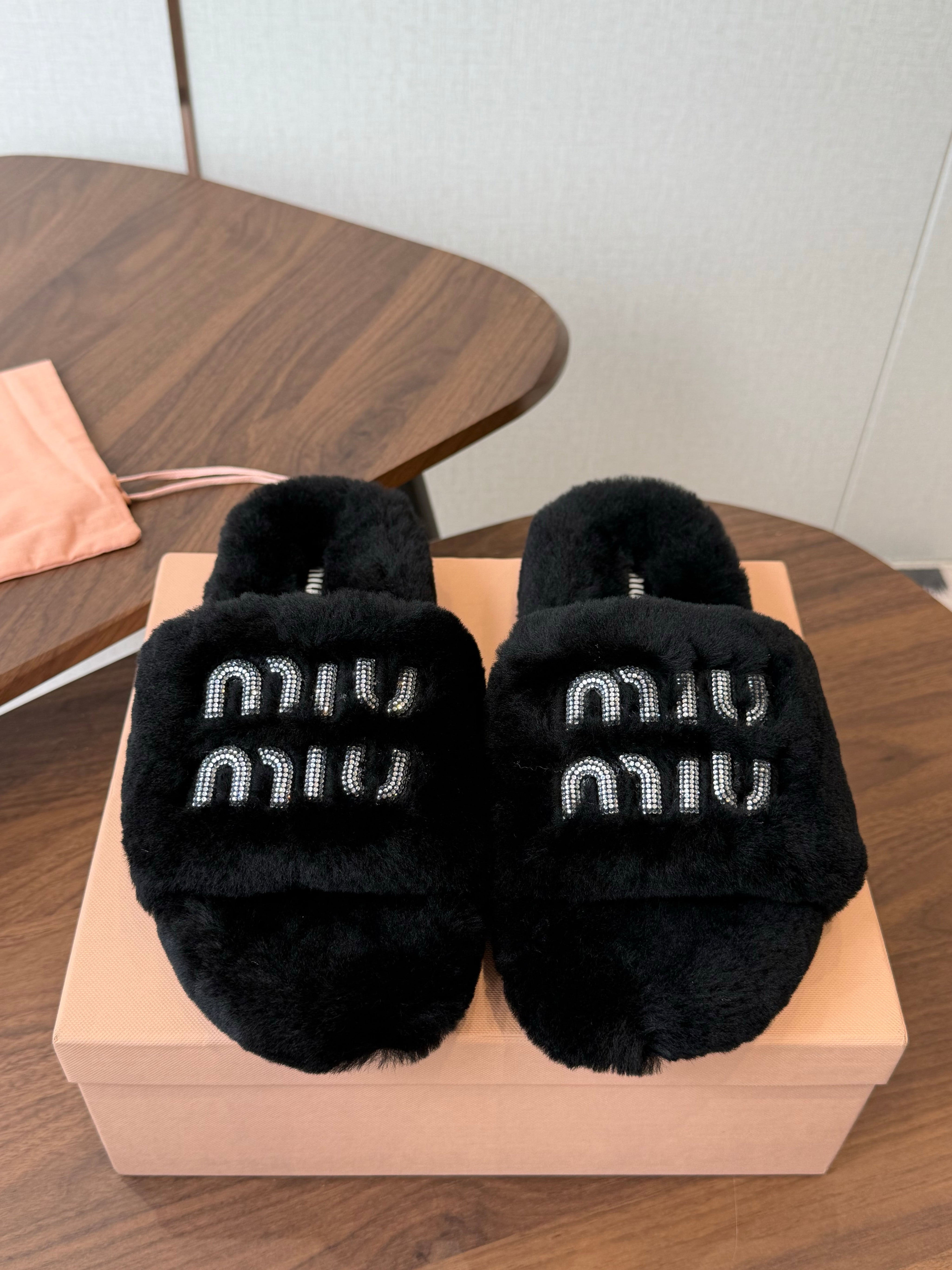 MIUMIU 26S CRYSTAL LOGO SLIDES IN BLACK SHEARLING