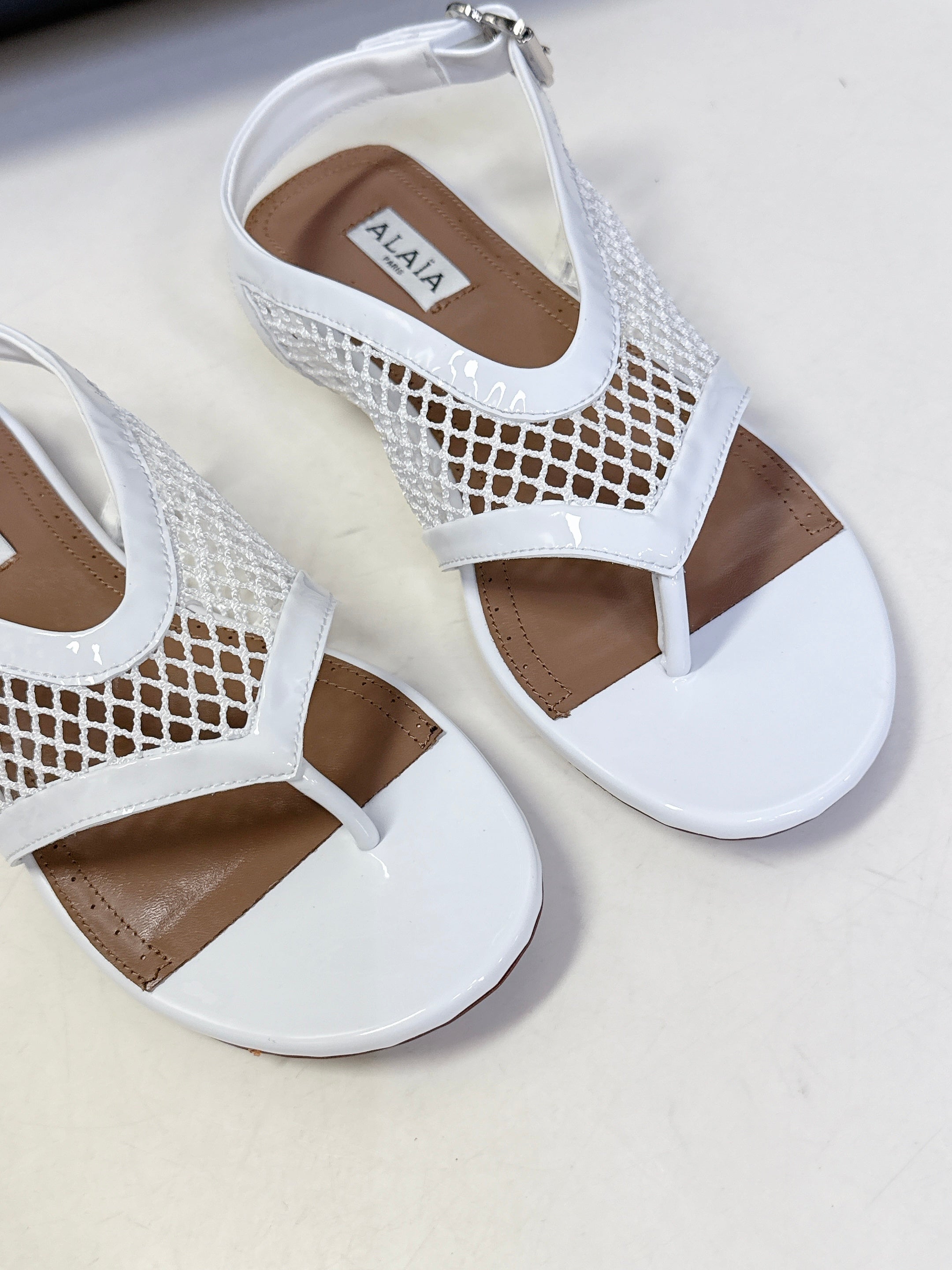 ALAIA 26S FLAT MESH THONG SANDALS IN WHITE PATENT CALFSKIN