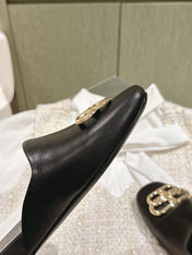 FLAT MULES IN BLACK SMOOTH CALFSKIN GOLD BUCKLE