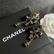 CHANEL 26S DOUBLE C LOGO BLACK ENAMEL BOW DANGLE EARRINGS WITH CHAIN CHARMS IN GOLD METAL 629178
