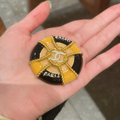 CHANEL 26S DOUBLE C LOGO PARIS ROUND ENAMEL BROOCH IN BLACK & AMBER WITH ROPE DETAIL GOLD METAL 629194