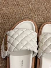 CHANEL 26S SLIDE SANDALS IN WHITE QUILTED CALFSKIN WITH LOGO PLAQUE