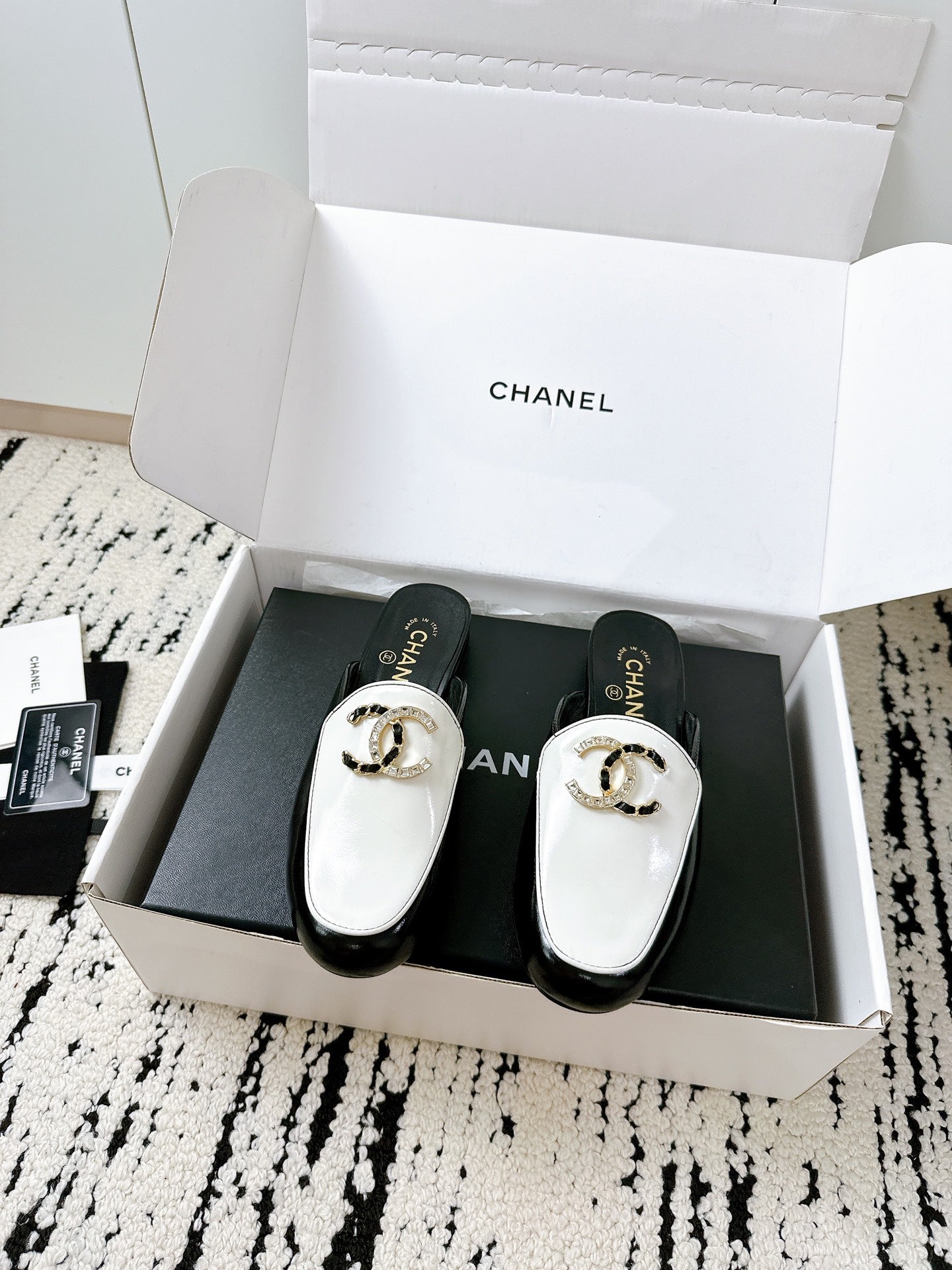 CC FLAT MULE IN WHITE AND BLACK CALFSKIN HARDWARE WITH ROCK MIX CHAIN
