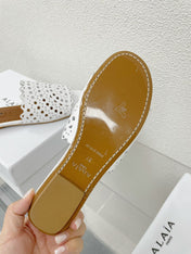 ALAIA VIENNE FLAT MULES IN WHITE LAMBSKIN